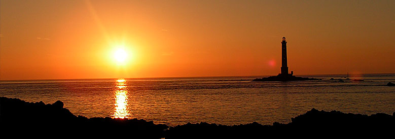 Panorama: Phare au loin. Soleil qui se couche